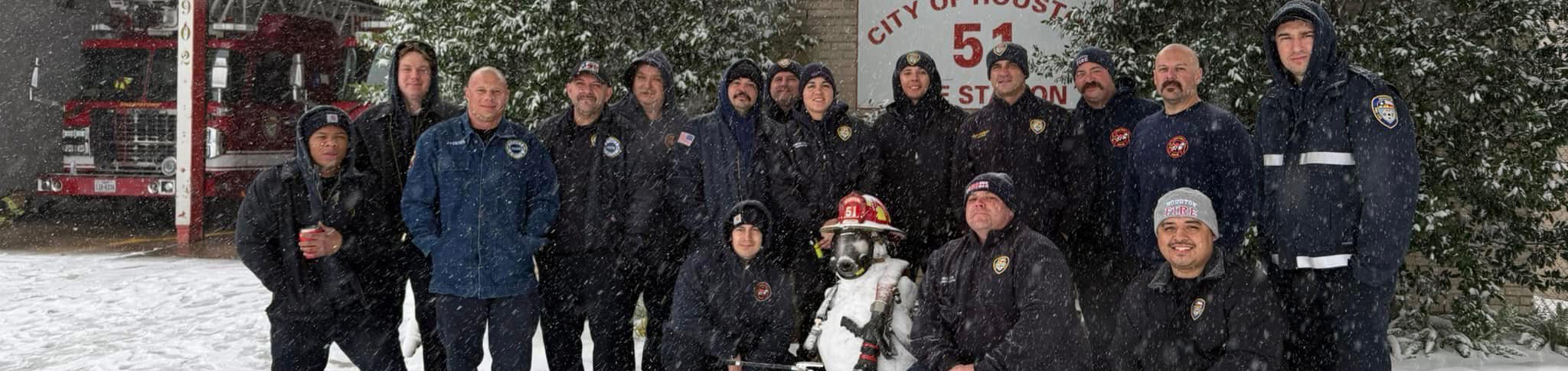 photo of HFD crew in front of their fire station during snow